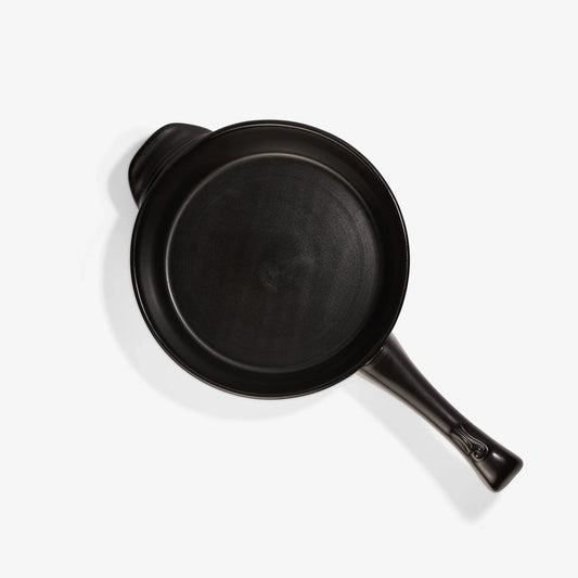 Top view of a professional matte black Xtrema pure ceramic frying pan on a white background.