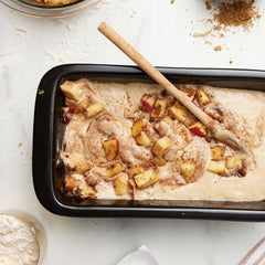 Apple cake batter with cinnamon and fruit chunks in a black Xtrema ceramic baking pan.