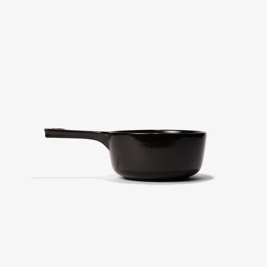 Professional black Xtrema pure ceramic saucepan with handle on a white background