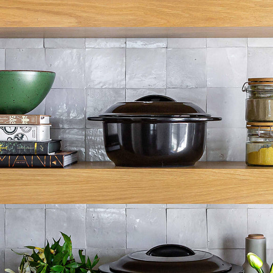 Professional Xtrema black ceramic pot with lid on a wooden kitchen shelf.