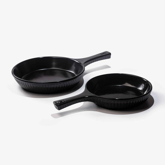 Two black Xtrema pure ceramic frying pans on a white background.
