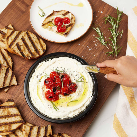 Xtrema ceramic bowl filled with whipped feta, roasted tomatoes, and olive oil with grilled bread.