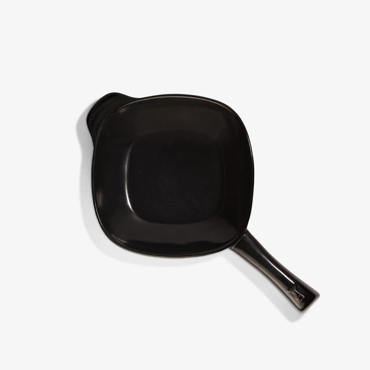 Top view of a black Xtrema pure ceramic frying pan with a handle on a white background.
