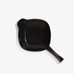 Top view of a black Xtrema pure ceramic frying pan with a handle on a white background.