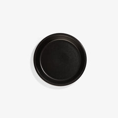 Top view of a matte black Xtrema pure ceramic pizza pan on a white background.