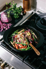 Fresh vegetable stir-fry cooking in an Xtrema pure ceramic skillet on a gas stove.