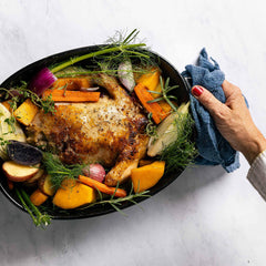 Roasted chicken with root vegetables in a black Xtrema ceramic roasting pan.