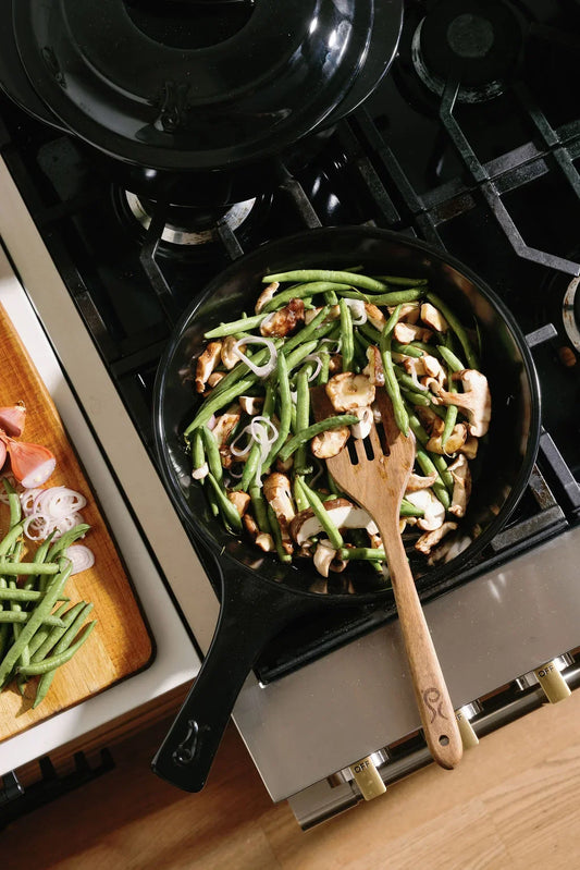 Sautéed green beans and mushrooms in an Xtrema ceramic skillet on a gas stove.