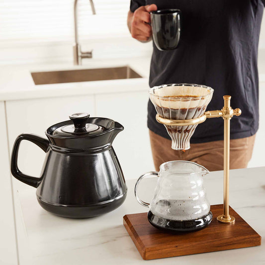 Xtrema black ceramic coffee pot and pour-over coffee maker on a white kitchen counter.