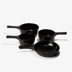 Set of four black Xtrema pure ceramic pots and pans on a white background.