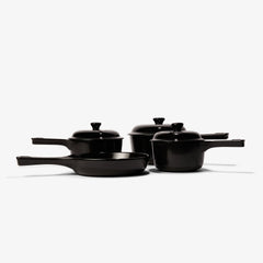 Set of black Xtrema pure ceramic cookware including pans and lidded pots on a white background.