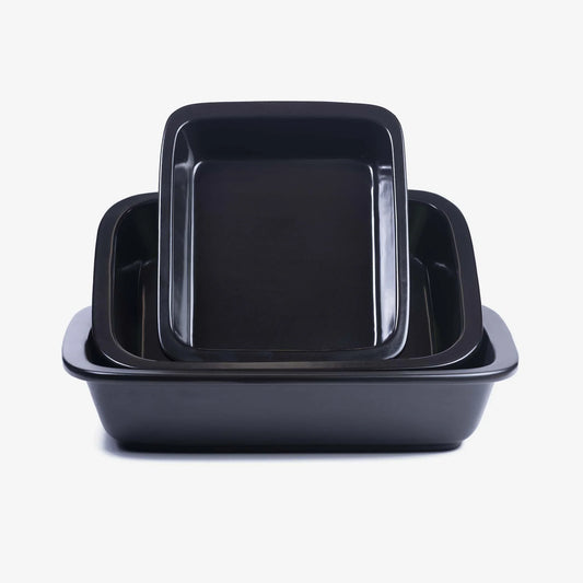 A stack of three black Xtrema pure ceramic rectangular baking dishes of varying sizes.
