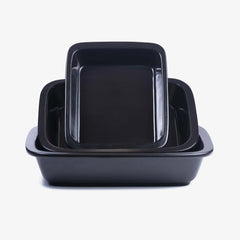 A stack of three black Xtrema pure ceramic rectangular baking dishes of varying sizes.