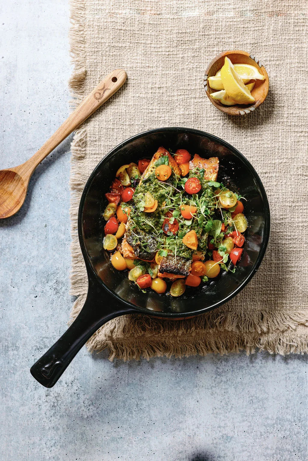 Pan-seared salmon with cherry tomatoes and pesto in an Xtrema ceramic skillet.