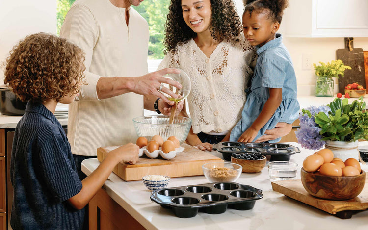 A family baking together in a kitchen using Xtrema ceramic cookware and fresh ingredients.